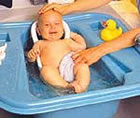 Baby in a blue baby bath tub.